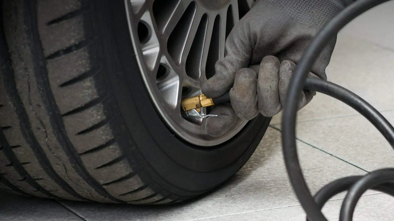 Technician checking tire tread depth and air pressure